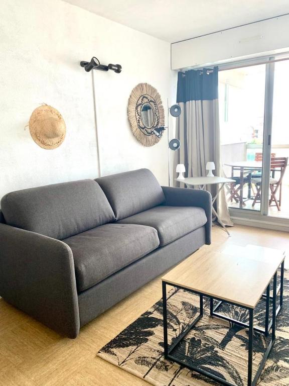 un salon avec un canapé et une table dans l'établissement Arcachon charmant studio sur le port aperçu mer., à Arcachon