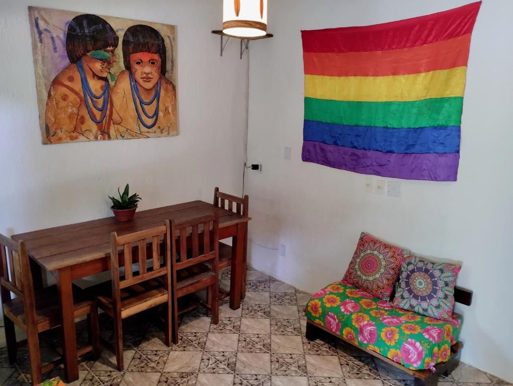 Zimmer mit einem Tisch und einer Regenbogenfahne in der Unterkunft Jurema Hostel in Itacaré