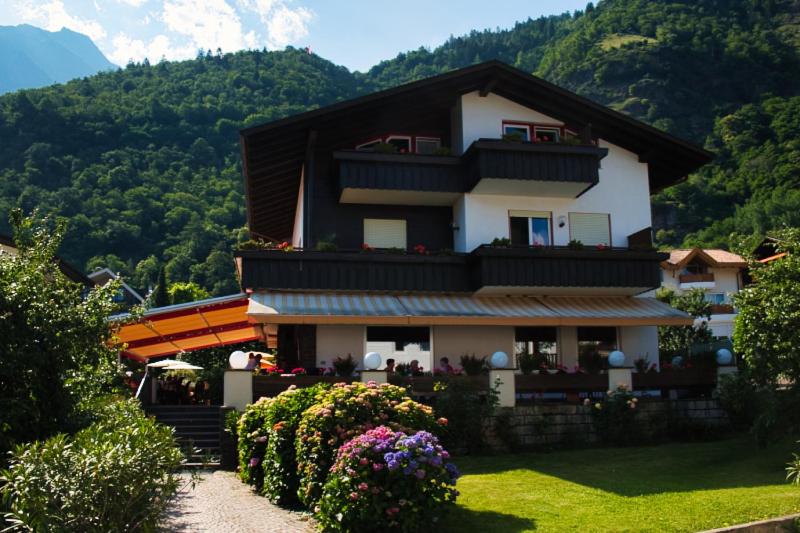 una casa grande con flores delante en Café Rudi Living, en Parcines