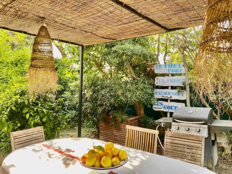 un bol de fruits sur une table avec un gril dans l'établissement Villa calme grand jardin bord de mer. Parking, à Marseille