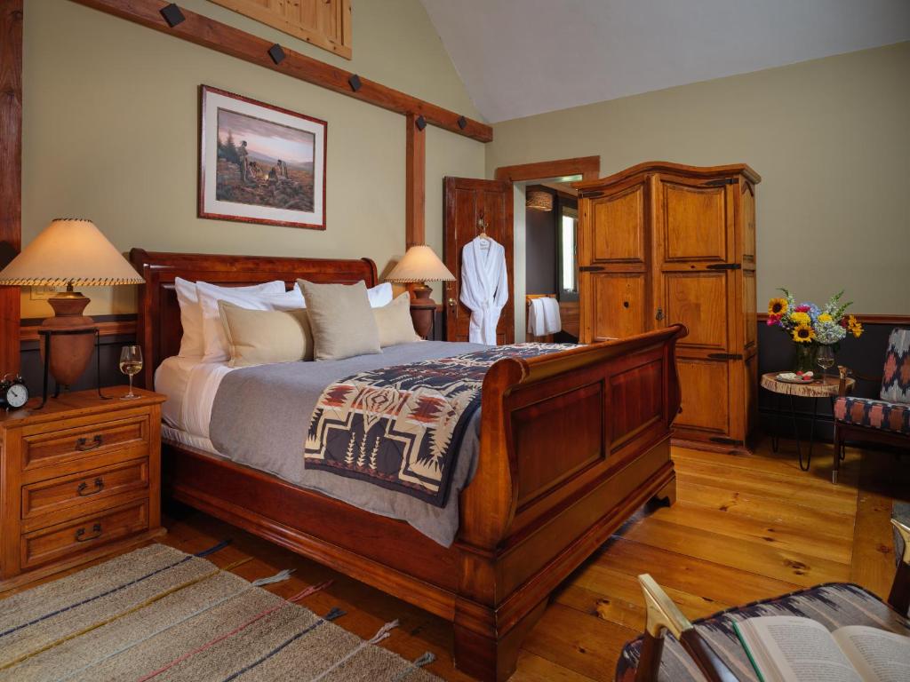 a bedroom with a large wooden bed and wooden floors at Abbey's Lantern Hill Inn in Ledyard Center