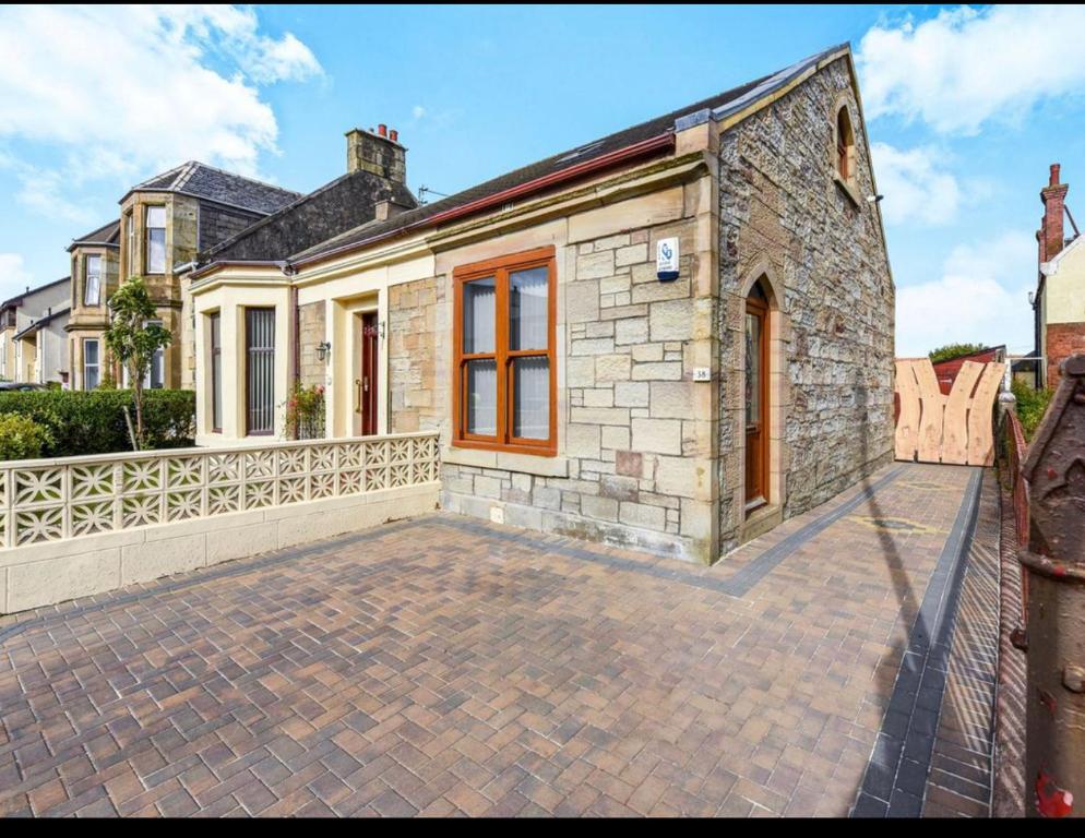 a stone house with a brick driveway at Seaside Home in Ardeer Square