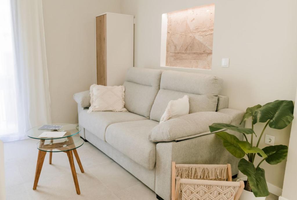 uma sala de estar com um sofá e uma planta em Casa Colgante con vistas panorámicas junto al mar. em Villajoyosa