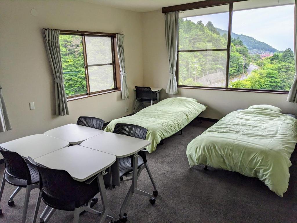 雲仙的住宿－H,U,B Unzen - Vacation STAY 78660v，一间设有两张床和一张桌子及椅子的房间