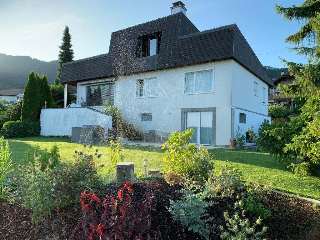 una casa con un jardín delante de ella en Retreat Lodge Schürmatt -Leben wie SchweizerInnen en Günsberg  