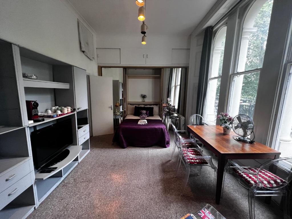 ロンドンにあるHyde Park Studio Has Private Balcony With Tranquil Garden Viewのリビングルーム(テーブル付)、ベッドルーム1室