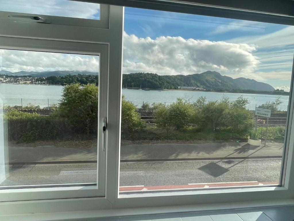 a window with a view of a body of water at Leerick Cottage in Conwy