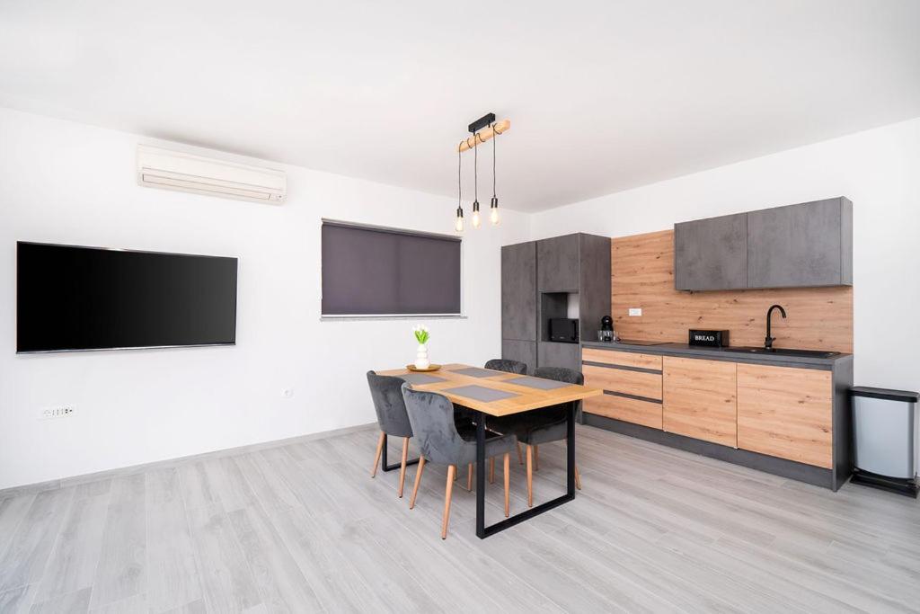 a kitchen with a wooden table and a dining room at Apartments Grubišić - Šibenik - parking included in Šibenik