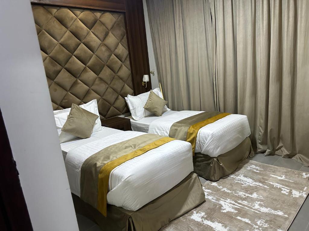 two beds in a hotel room withskirts at الاتحاد الذهبية للشقق المخدومة 3 in Al Hofuf