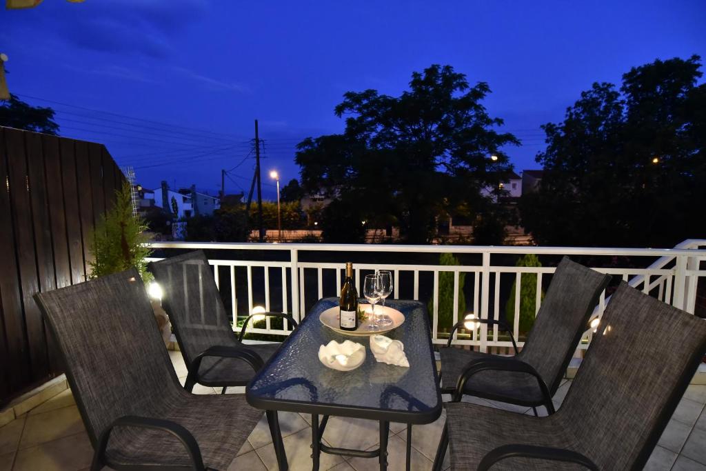 una mesa y sillas en un balcón por la noche en Holiday blue, en Palaión Tsiflíkion