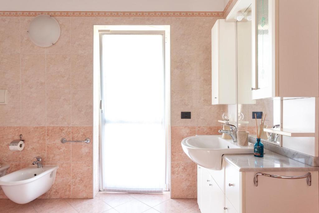 een badkamer met een wastafel, een toilet en een spiegel bij Apartment MisiAdele in Carnago
