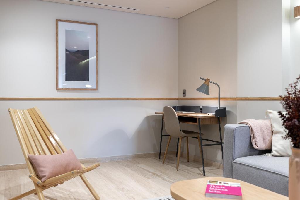 A compact in-room sitting area with a desk and lounge chair.