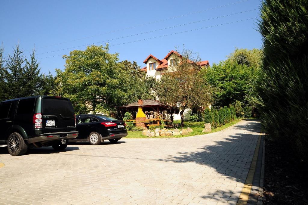 zwei Autos, die auf einer Einfahrt vor einem Haus geparkt sind in der Unterkunft Dom Lwowski in Sanok