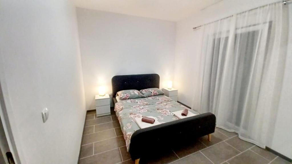 a small bedroom with a bed and two lamps at Tonka in Vodice