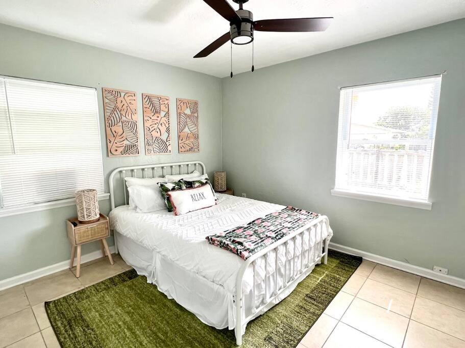 a bedroom with a white bed with a ceiling fan at Palm Paradise in downtown Cocoa Beach in Cocoa Beach
