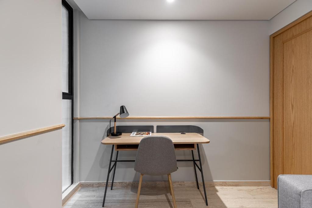 A dedicated desk tucked beside a window in the apartment.