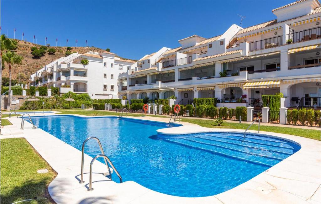 a swimming pool in front of a building at Lovely Apartment In Mlaga With Kitchenette in Málaga