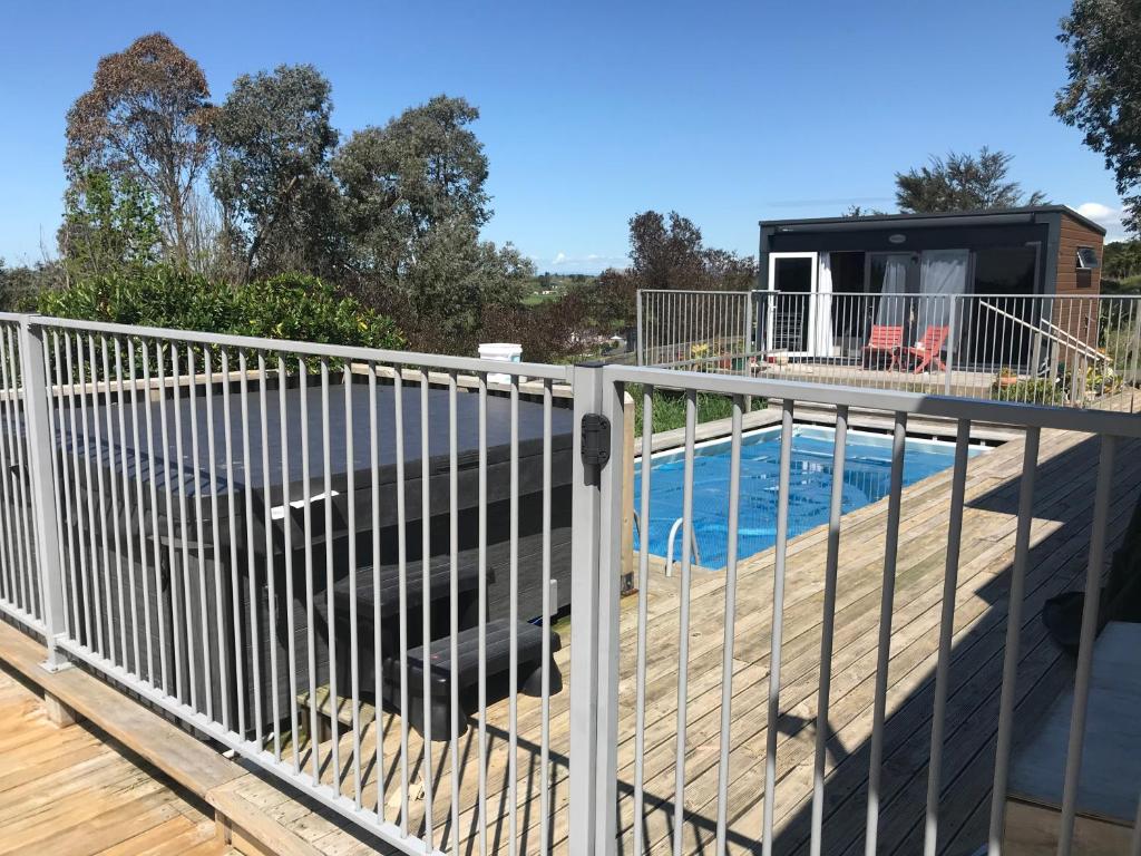 a fence on a deck next to a swimming pool at Perma Ridge Farmstay in Ngaruawahia