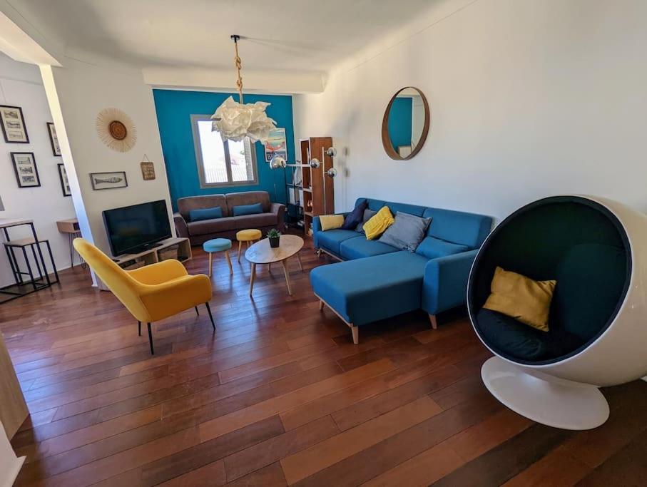 - un salon avec un canapé bleu et des fauteuils jaunes dans l'établissement Loft 80m2 Bandol dernier étage à 100m plage, centre, port, à Bandol