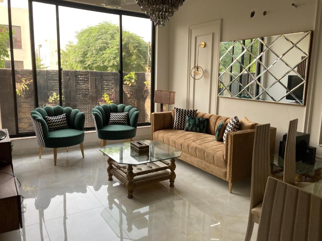 a living room with a couch and chairs and a table at Homey Stays - 3 Bedroom Holiday Home - DHA in Lahore