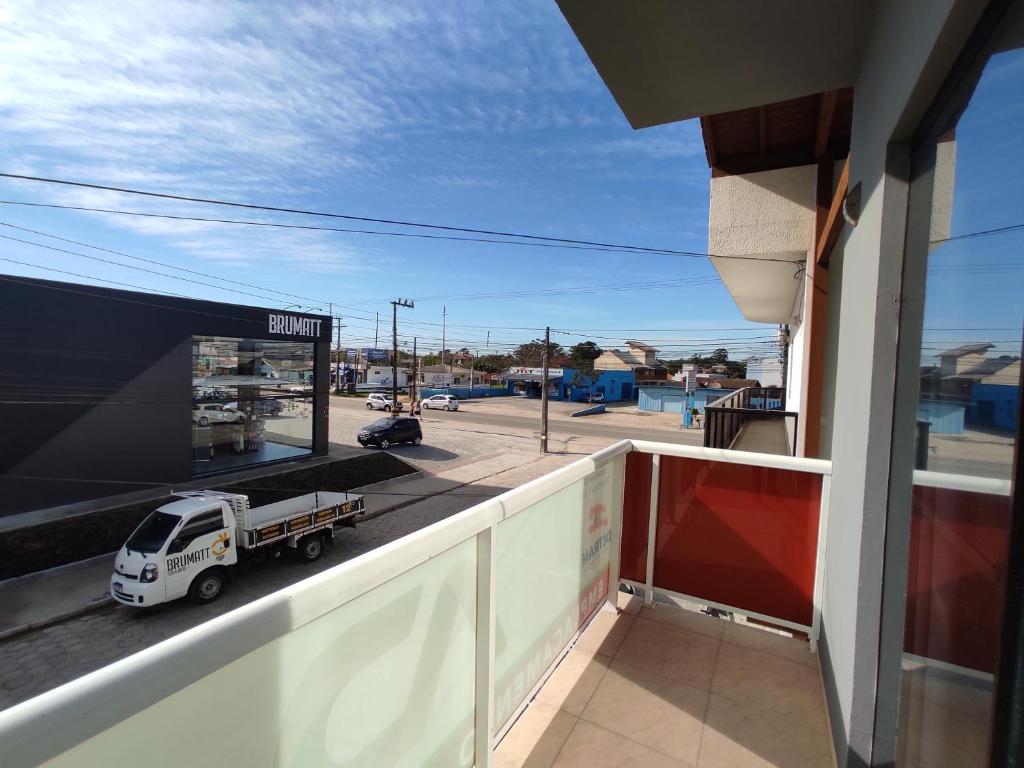 a view of a truck on a street from a balcony at Apto próximo a Lagoa do Ibiraquera in Garopaba