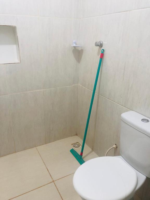 uma casa de banho com um WC e uma esfregona verde em Pousada Voadores Jalapão em Mateiros