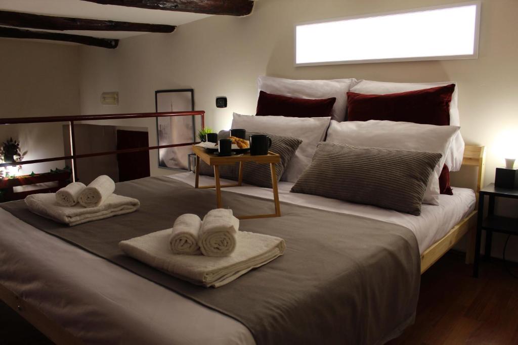 - une chambre avec un grand lit et des serviettes dans l'établissement Pedamentina Pulcinella Loft, à Naples