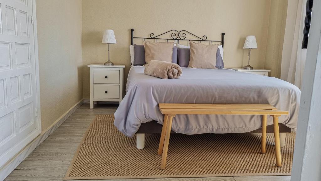 sypialnia z dużym łóżkiem i drewnianym stołem w obiekcie Palm House w Marbelli