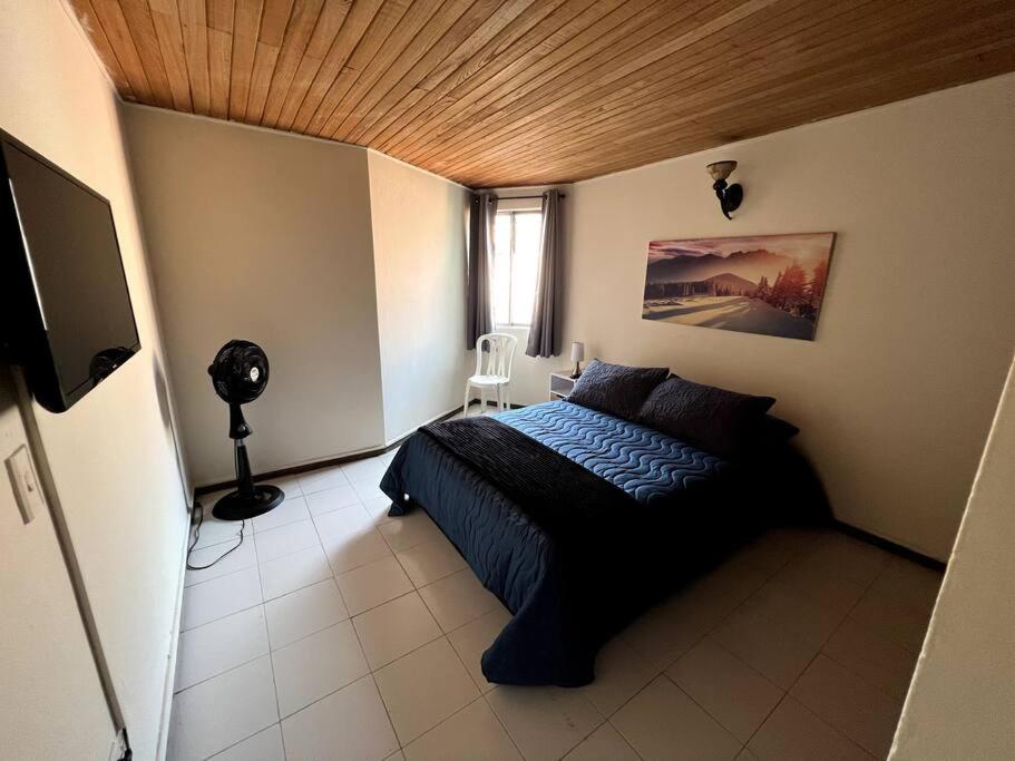 a bedroom with a bed with a wooden ceiling at hermoso y amplio apartamento con desayuno incluido in Medellín