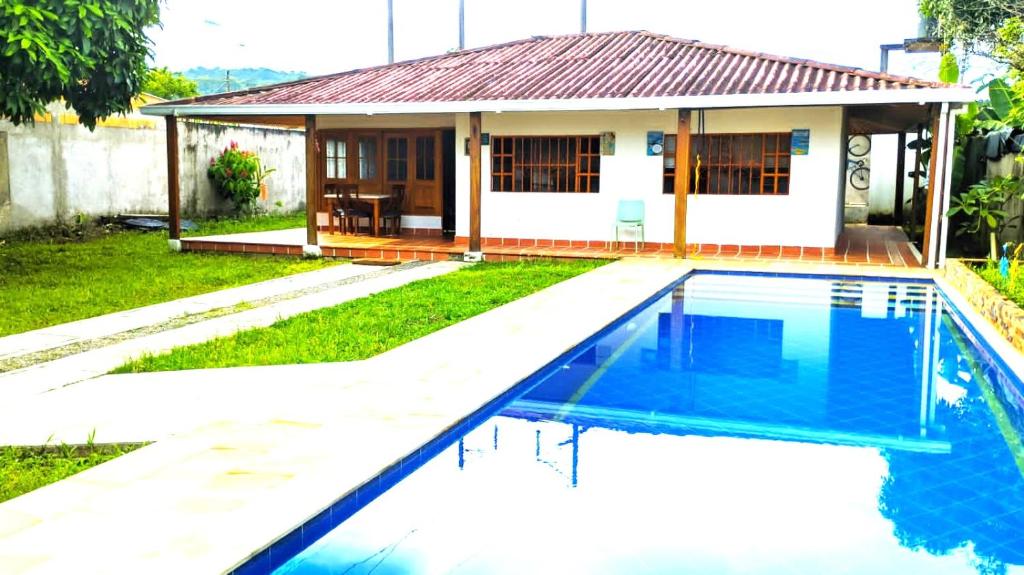 a villa with a swimming pool in front of a house at Casa de descanso acacias meta in Acacías