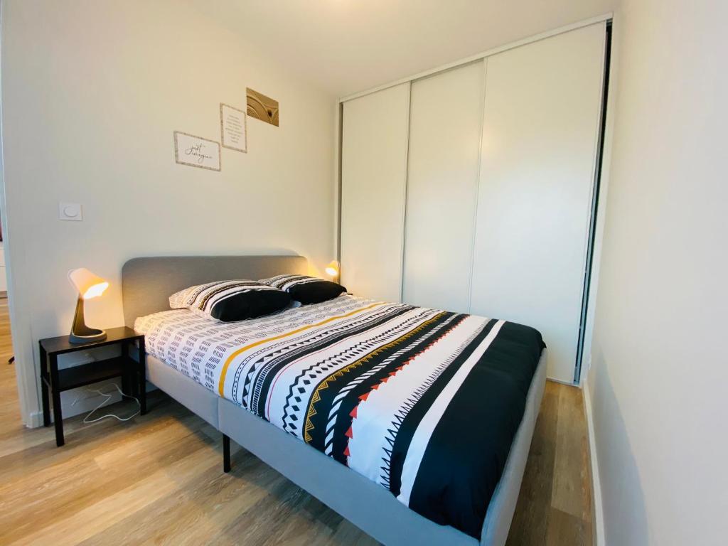 een slaapkamer met een bed en een grote kast bij Cozy appart' a deux pas de la gare - Cozy Houses in Palaiseau