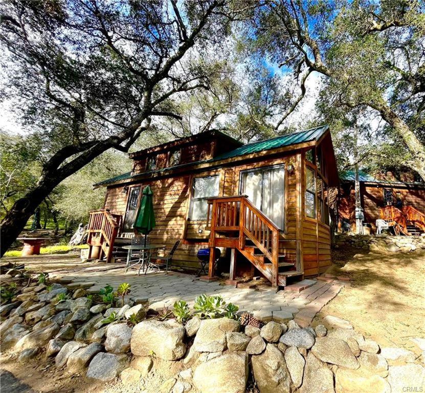 een houten hut met een veranda en een terras bij Oak Knoll Village in Palomar Mountain