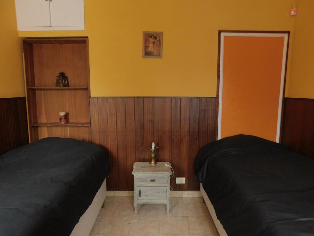 a bedroom with two beds and a yellow wall at Patagonia Andina in Zapala