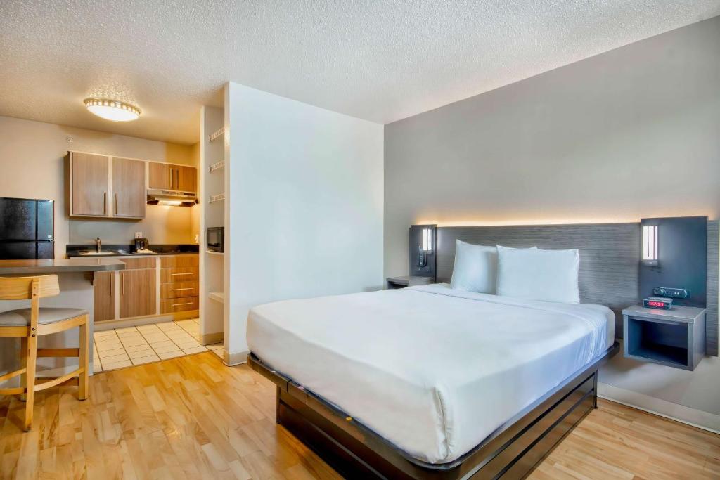 a bedroom with a large bed and a kitchen at Studio 6-San Antonio, TX - Medical Center in San Antonio