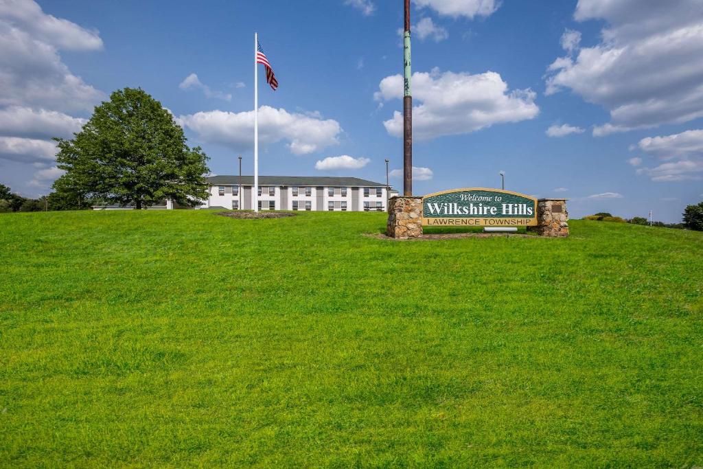 a sign in the grass in front of a white building at Sleep Inn in Bolivar