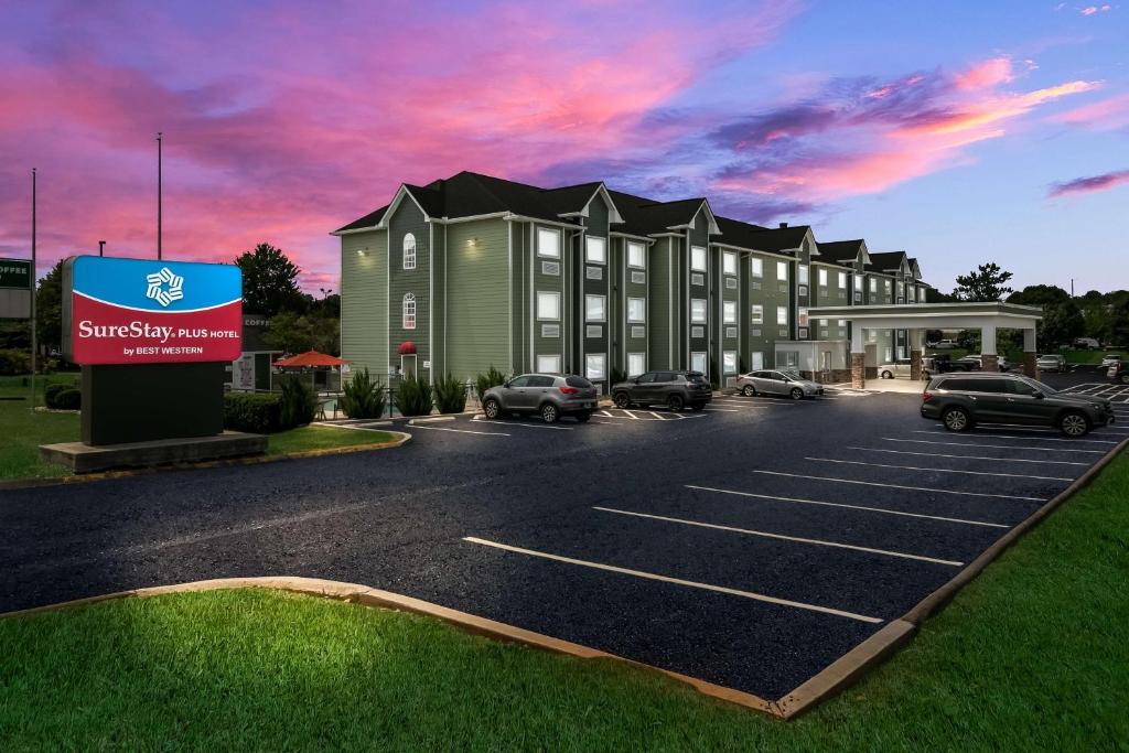 a building with cars parked in a parking lot at SureStay Plus Hotel by Best Western Sevierville in Sevierville