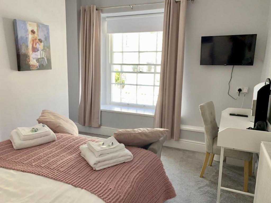 een slaapkamer met een bed met handdoeken erop bij Seaclyffe Hotel Ltd in Llandudno