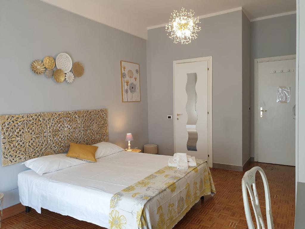 Un dormitorio con una cama blanca y una lámpara de araña. en Holiday Max, en Roma