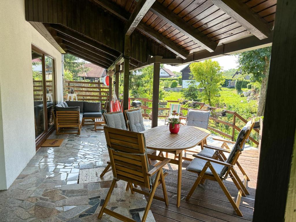 een houten tafel en stoelen op een patio bij Kuća za odmor PIKA in Duga Resa