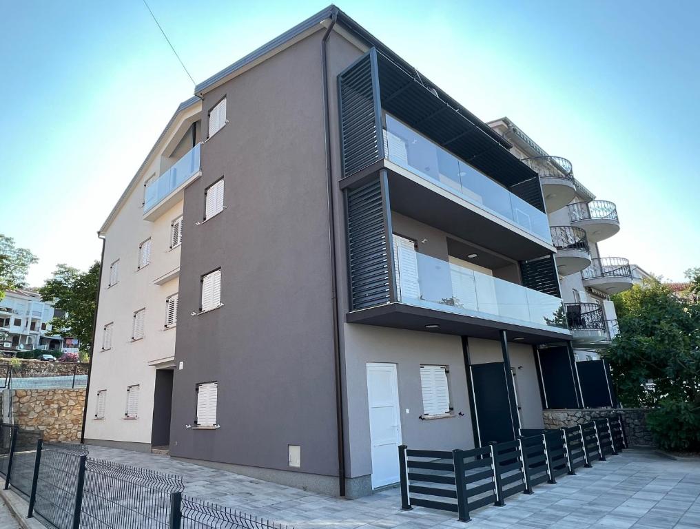 ein Apartmenthaus mit Balkon auf einer Straße in der Unterkunft Apartmani AViS in Selce