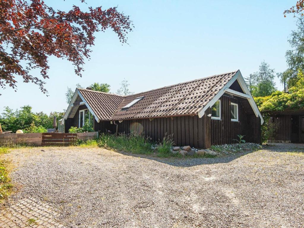 een huis met een dakraam en een tuin bij 6 person holiday home in Ebeltoft in Ebeltoft