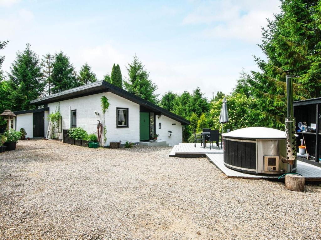 une petite maison blanche avec une grande cour dans l'établissement 4 person holiday home in Ebeltoft-By Traum, à Ebeltoft