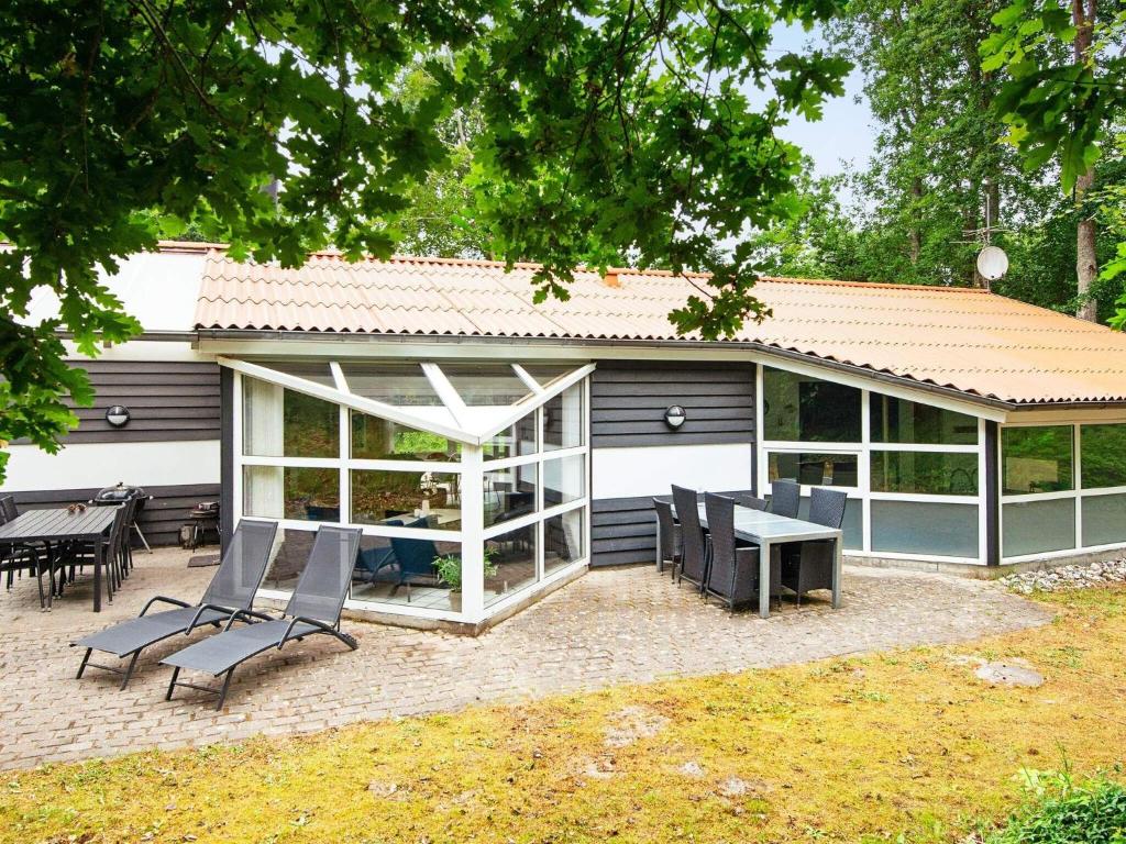 a house with a patio and a table and chairs at Holiday home Glesborg VI in Glesborg