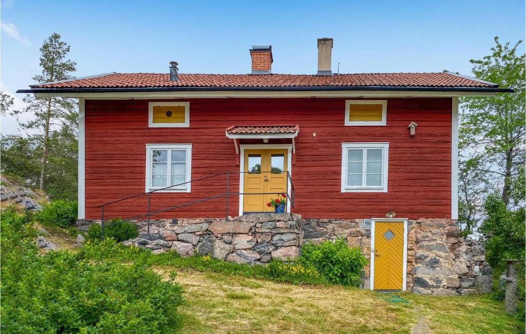 una casa roja con puertas amarillas en una colina en Lillstugan en Valdemarsvik