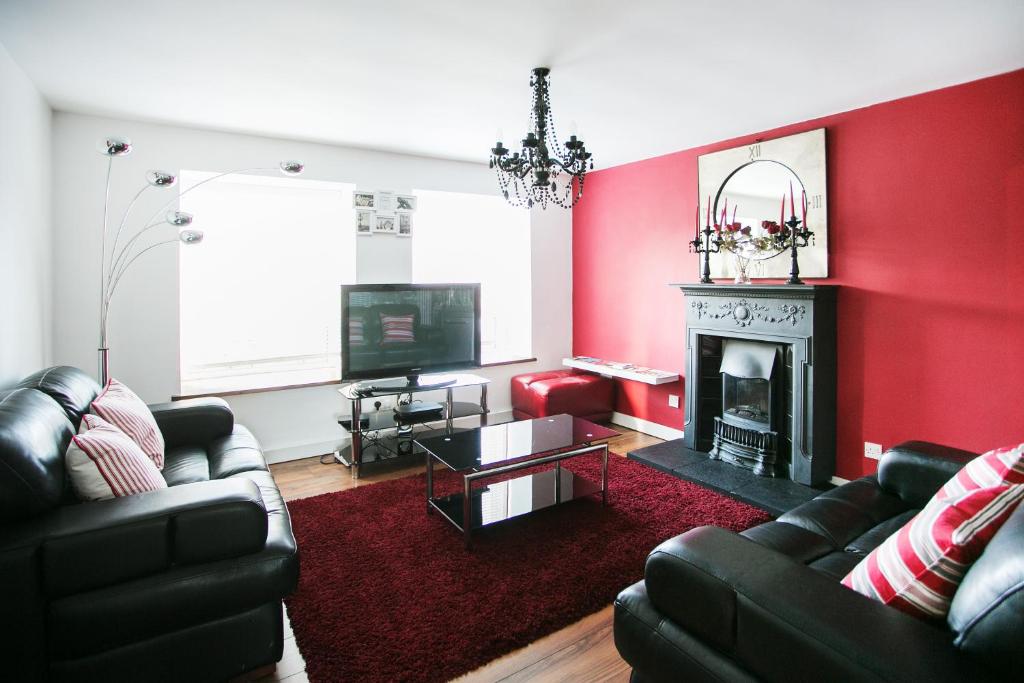 a living room with red walls and a fireplace at So-Cute Cityside in Belfast