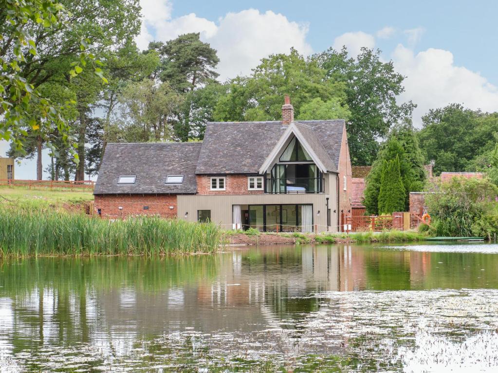 a house next to a body of water at Lakeside Lodge in Wolverhampton