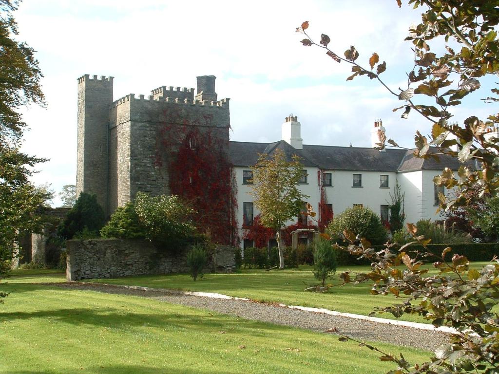 uma casa com um castelo no meio de um quintal em Barberstown Castle em Straffan