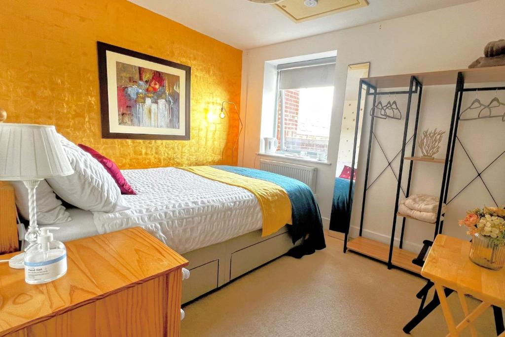 Schlafzimmer mit einem Bett, einem Tisch und einem Fenster in der Unterkunft GOLD Penthouse Room 5min to Basingstoke Hospital in Basingstoke