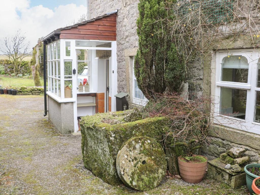 a stone house with a door and a window at Sycamore Cottage in Hucklow