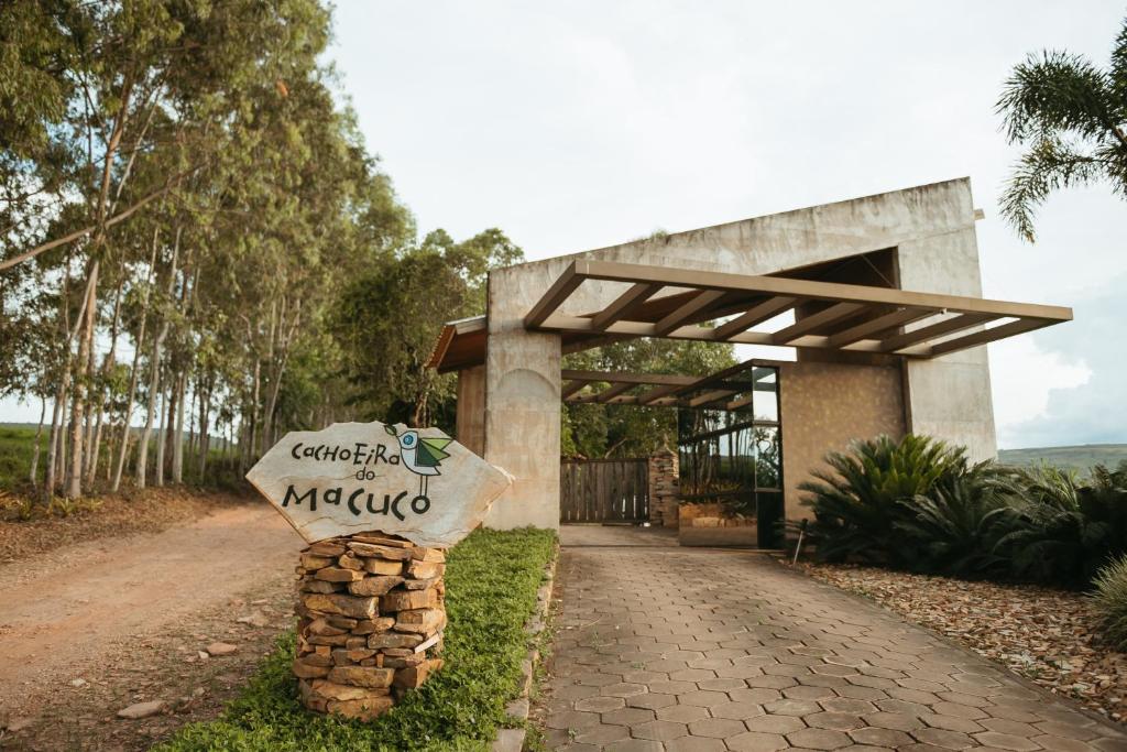 a sign on a path in front of a building at Cachoeira do Macuco Boutique Hotel in Guapé